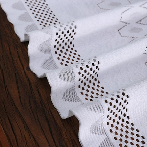 Elegant white lace table runner with hollow mesh design on a vintage wood surface