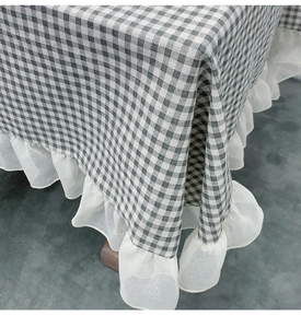 Detailed view of plaid tablecloth with white ruffle edges and thick cotton linen texture
