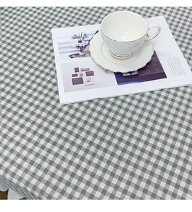 Detail of grey and white checkered linen tablecloth with fabric texture and coffee cup