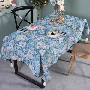 Nordic oil-painted floral table runner with white fringe tassels on a wooden dining table