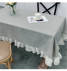 Detail view of checkered linen tablecloth with decorative white lace ruffles and hem