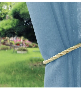 Detail of golden spiral tieback on sheer blue waterproof curtain for outdoor gazebos