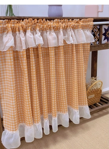 Detailed view of orange checkered cafe curtain with double-layered lace ruffled edges