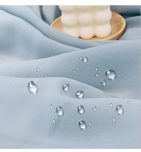 Macro view of light blue waterproof gazebo curtain fabric showing hydrophobic water droplets