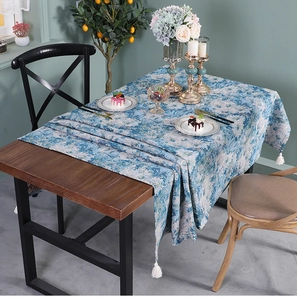 Close-up of blue floral table runner with elegant white tassels and oil painting texture