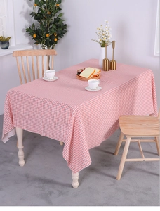 Detailed macro view of pink and white checkered cotton linen tablecloth with fringe edges