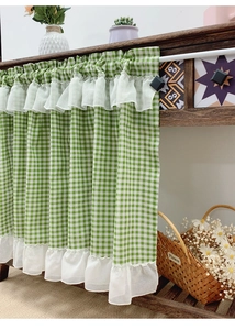 Close-up of green checkered coffee curtain with white lace ruffles and linen texture