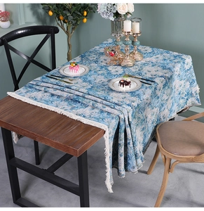 Detailed view of blue floral oil painting table runner with elegant white fringe tassels
