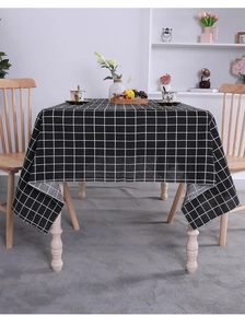 Detailed view of black and white checkered cotton linen tablecloth in a home dining setting