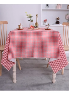 Detailed texture of red and white checkered linen cotton tablecloth on a wooden table