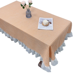 Orange and white checkered tablecloth with white ruffle lace edges on a white background