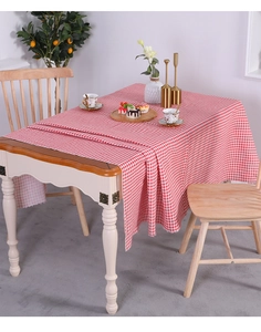 Detailed view of red and white checkered linen tablecloth with hemmed edges on a table