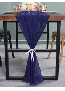 Marineblauwe tafelloper met kreuktextuur en wit lint voor een elegante eettafel decor