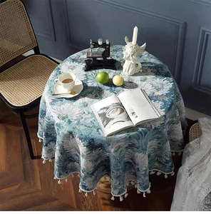 Detail of bohemian round tablecloth with floral patterns and white fringe edges