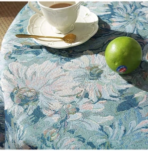 Close-up of blue jacquard floral tablecloth fabric with a luxurious silk-like woven texture