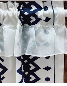 Detail of bohemian cafe curtain featuring blue geometric patterns and layered ruffle edges