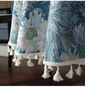 Close-up of bohemian blue floral jacquard tablecloth with elegant white fringe tassels