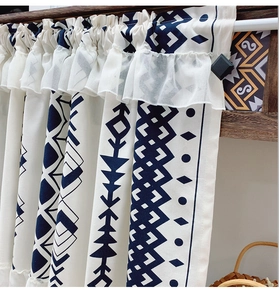 Detail of bohemian cafe curtain with blue geometric prints and double ruffle lace trim