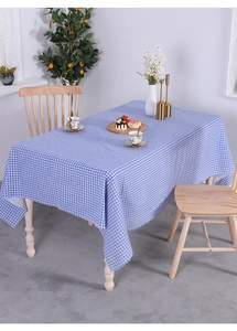 Close-up of blue and white checkered cotton linen tablecloth on a wooden table