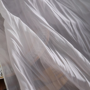 Witte crinkle chiffon tafelloper met geplooide textuur op een donker houten blad