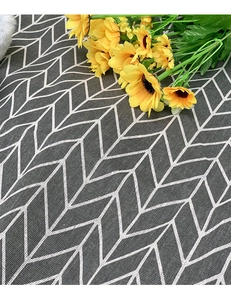 Detail of grey herringbone pattern picnic mat fabric with decorative yellow flowers