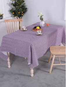 Detail of purple gingham linen tablecloth with textured weave and fringe edge design