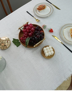 Close-up of white Nordic linen tablecloth featuring elegant tassel edges and rich texture