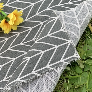 Outdoor portable picnic mat with grey geometric patterns on green grass background