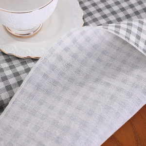 Grey and white plaid linen tablecloth with detailed weave texture and white hemmed edges