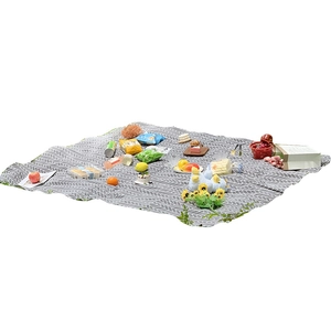 Portable gray and white herringbone picnic mat with snacks and fruits for outdoor trips