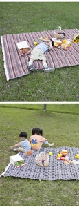 Detailed view of bohemian style woven picnic mat with ethnic patterns and fringe edges