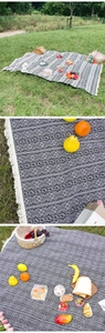 Detailed view of Bohemian ethnic style picnic blanket with elegant fringe edges outdoors