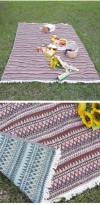 Macro detail showing the intricate woven Bohemian pattern and white fringe of the picnic mat.