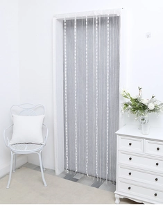 Detail of white minimalist tassel string curtain with decorative woven stripe patterns