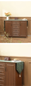 Détail d'un chemin de table en velours avec lignes dorées et finitions de pompons blancs