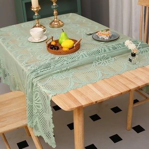Nappe en dentelle au crochet vert clair avec motifs floraux sur table bois
