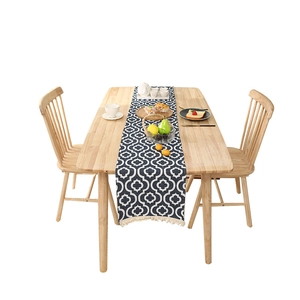 Nordic blue chenille table runner with geometric jacquard and tassels on wooden table