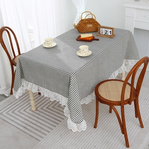 Linen plaid tablecloth with white lace edges on a rectangular dining table in a cozy room