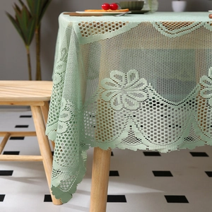 Gros plan sur la nappe en dentelle au crochet vert clair aux motifs floraux ajourés