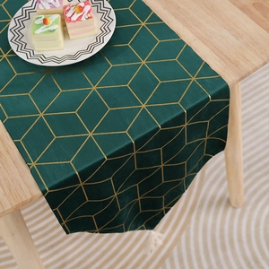 Détail du chemin de table vert foncé en velours avec lignes dorées et pompon blanc