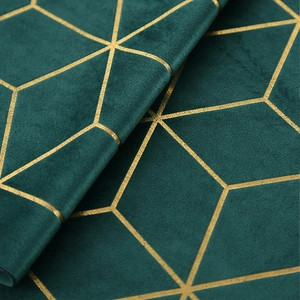 Gros plan du chemin de table en velours émeraude avec motifs géométriques dorés chics