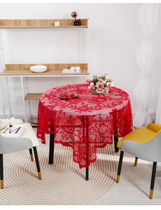 Close-up of red lace tablecloth featuring intricate floral patterns and scalloped edges