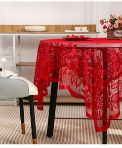 Detail of red lace tablecloth showing intricate hollow mesh and rose floral patterns