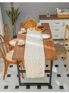 Detail of bohemian khaki and cream table runner with ethnic weave and neat fringes