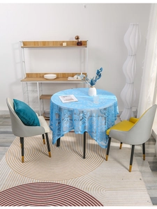 Detail of light blue lace tablecloth with hollow flower pattern on round table