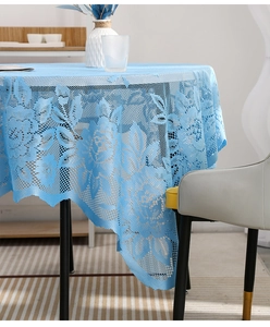 Detailed close-up of light blue lace tablecloth with elegant floral jacquard patterns