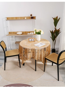 Detailed close-up of champagne gold lace tablecloth with intricate floral cut-out patterns
