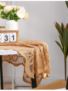 Detailed view of khaki lace tablecloth with floral hollow patterns and wavy edges