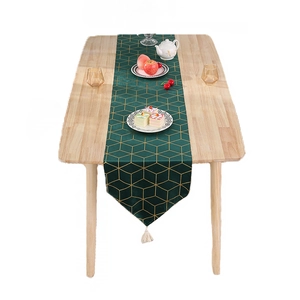 Chemin de table vert foncé avec motifs géométriques dorés et pompons pour déco chic