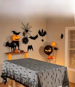 Close-up of black lace tablecloth featuring bat and dry tree motifs for Halloween decor